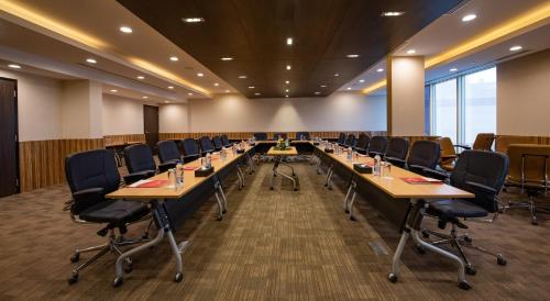 a large conference room with long tables and chairs at Ramada Hotel & Suites by Wyndham Al Qassim in Al Bukayriyah