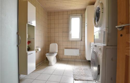 a bathroom with a toilet and a washer and dryer at Beautiful Home In Vemb With Wifi in Thorsminde