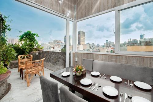 a dining room with a table and chairs and a large window at Valentine Boutique hotel - 29 Bui Vien street in Ho Chi Minh City