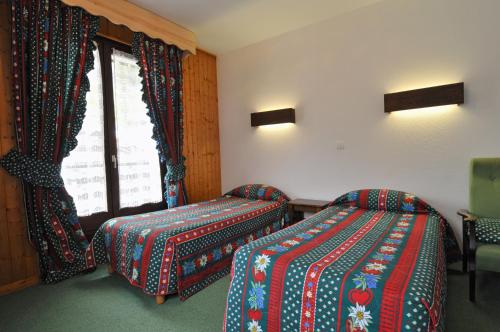 a hotel room with two beds and a window at Hôtel Le Mont Jorat in Abondance