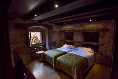 ein Schlafzimmer mit einem großen Bett in einem Steinzimmer in der Unterkunft Hotel El Convento de Mave in Santa María de Mave