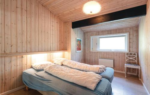 Vester SømarkenにあるAmazing Home In Nex With Saunaのウッドパネルの壁の客室で、ベッド2台が備わります。