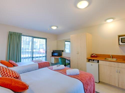 a hotel room with two beds and a kitchen at Bella Vista Motel Blenheim in Blenheim