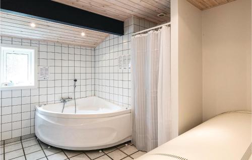 Vester SømarkenにあるAmazing Home In Nex With Saunaの白いタイル張りのバスルーム(白いバスタブ付)