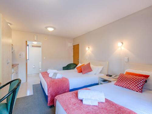 a hotel room with two beds and a table at Bella Vista Motel Blenheim in Blenheim