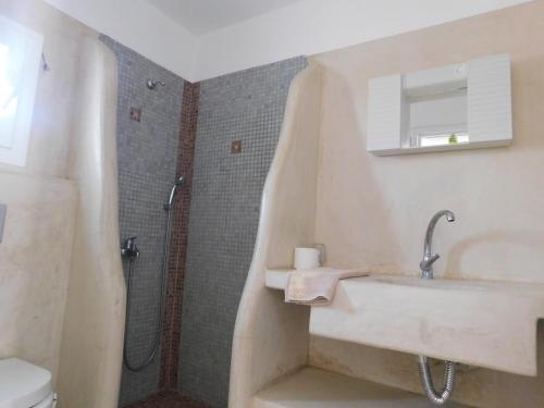 a bathroom with a sink and a shower at Sea Side Perivolos in Perivolos