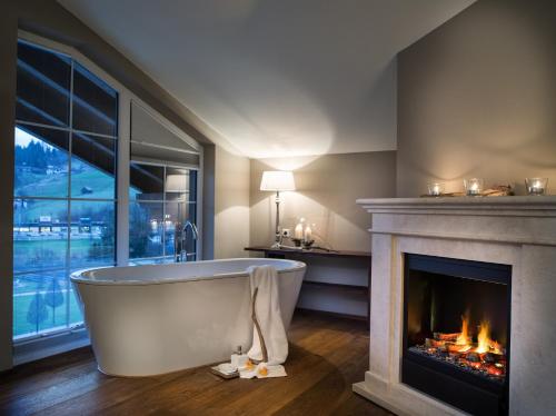 a bath tub in a room with a fireplace at Gut Weissenhof in Radstadt