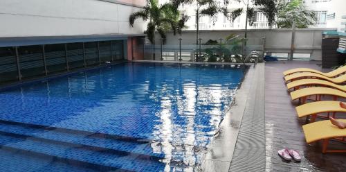 een zwembad met 2 stoelen en een gebouw bij 101 Newport Boulevard in Manilla