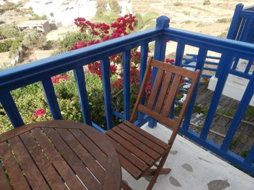 a wooden chair sitting on a balcony with flowers at Galini Bungalows in Kionia