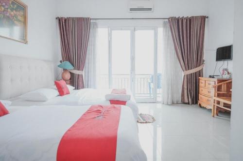 a bedroom with two beds and a large window at RedDoorz Syariah At Lampung Walk in Bandar Lampung