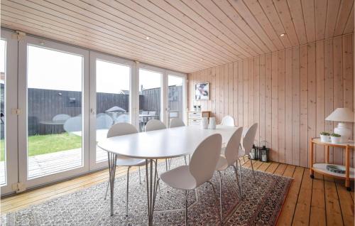 a dining room with a white table and chairs at Three-Bedroom Holiday Home In Juelsminde in Sønderby