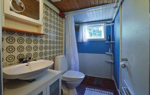 uma casa de banho com um lavatório branco e um WC. em Awesome Home In Hjby With Kitchen em Højby