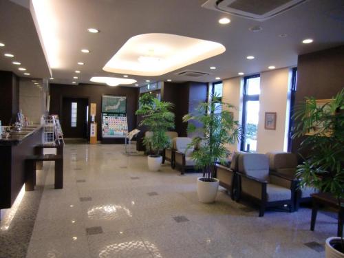 a lobby with a waiting room with potted plants at Hotel Route-Inn Oyama in Oyama