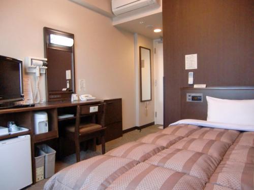 Tempat tidur dalam kamar di Hotel Route-Inn Oyama
