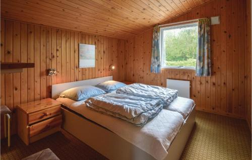 HemmetにあるNice Home In Tarm With 3 Bedroomsの木造キャビン内のベッド1台が備わるベッドルーム1室を利用します。