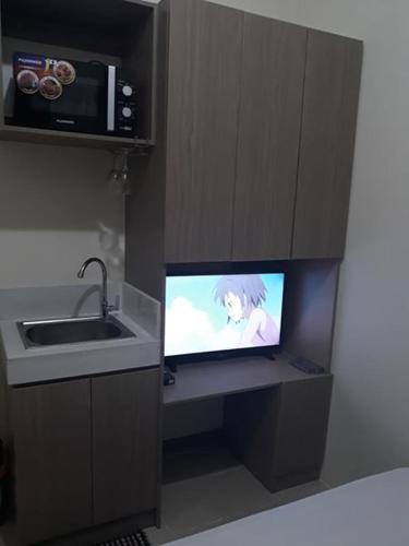 Il comprend une cuisine équipée d'un évier et d'une petite télévision. dans l'établissement Edsa Urban Deca Tower Condo Unit with Wifi and Netflix, à Manille