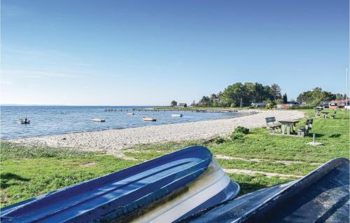a stack of books sitting on a bench next to a beach at Three-Bedroom Holiday Home In Ronde in Rønde