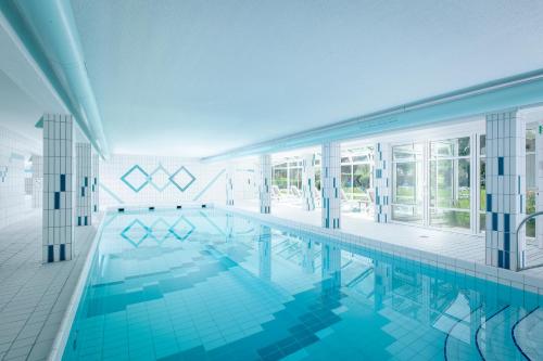 a swimming pool in a building with blue tiles at Farbinger Hof in Bernau am Chiemsee