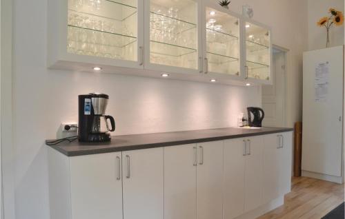 a kitchen with white cabinets and a blender on a counter at Holiday Home Lyngshuse Xi in Kølkær