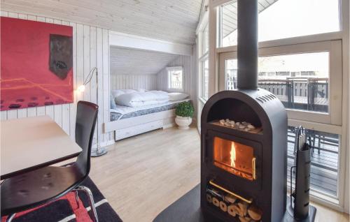 オテルプにあるAwesome Home In Otterup With 2 Bedrooms And Wifiのベッド付きの部屋に薪ストーブが備わる部屋