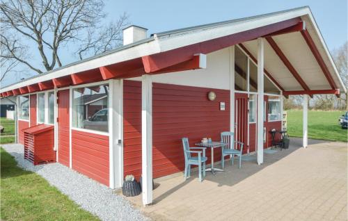 a red and white house with a table and chairs at Two-Bedroom Holiday Home In Aabenraa in Aabenraa