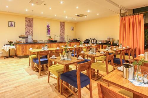 a dining room with wooden tables and chairs at Centro Hotel Braunschweig City, Trademark Collection by Wyndham in Braunschweig