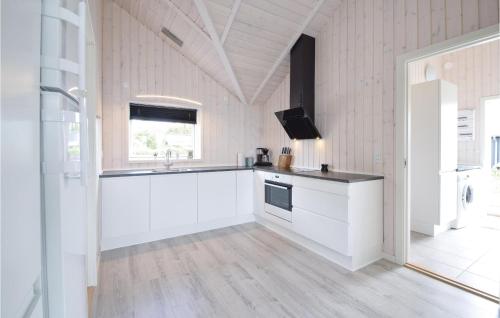a kitchen with white cabinets and a sink and a tv at Four-Bedroom Holiday Home In Malling in Malling