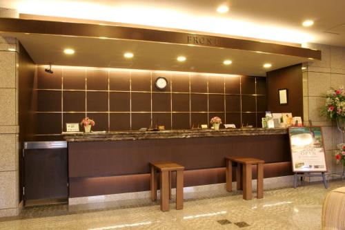 um restaurante com um balcão e dois bancos em Hotel Route-Inn Tsuruga Ekimae em Tsuruga