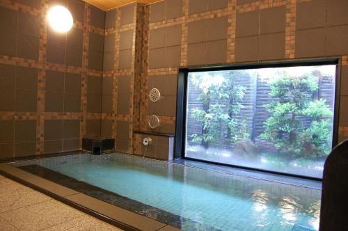 a swimming pool with a large tv in a bathroom at Hotel Route-Inn Tsuruga Ekimae in Tsuruga