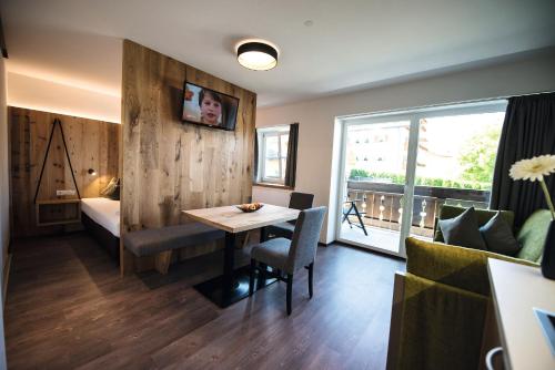 a hotel room with a table and a bed at Appartements Bergheim St Andrä bei Brixen in Bressanone