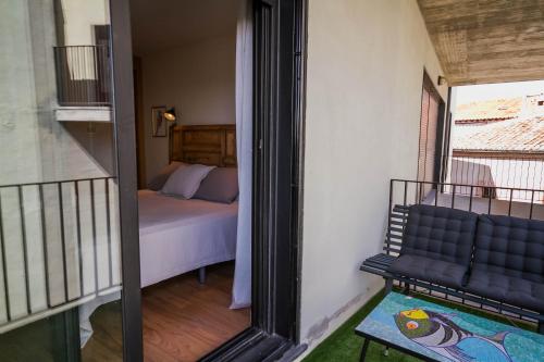 1 dormitorio con 1 cama y balcón con espejo en Mi Villa Arévalo, en Arévalo
