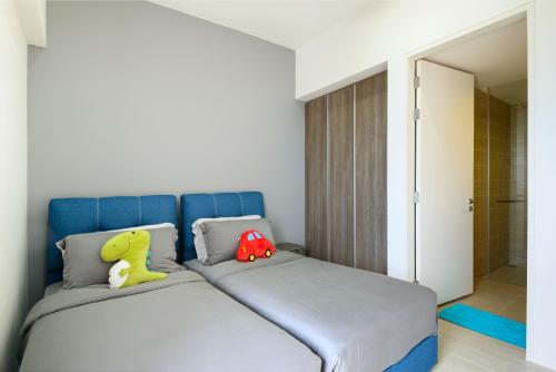 two stuffed animals sitting on a bed in a bedroom at By The Sea Beach Front Apartment in Batu Ferringhi