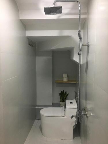 a white bathroom with a toilet and a shower at Hanoi Center Silk Lullaby Hotel and Travel in Hanoi