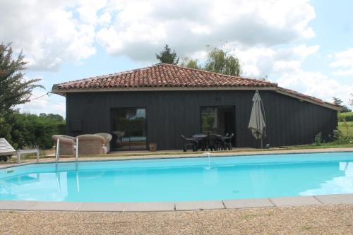 a house with a swimming pool in front of it at La Bastide in Lagrange