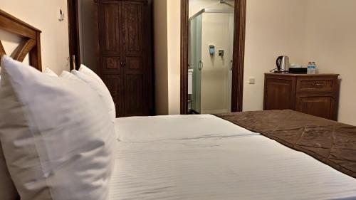 a bedroom with a bed with white sheets and pillows at Maajid Boutique Hotel in Baku
