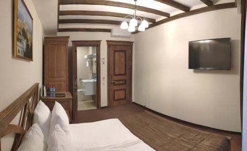 a bedroom with a bed and a flat screen tv at Maajid Boutique Hotel in Baku