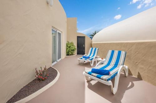 two blue and white chairs sitting on a patio at Hotel LIVVO Risco del Gato Suites in Costa Calma