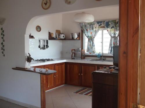 a kitchen with wooden cabinets and a sink and a window at Maison de Vacanze in Baie Sainte Anne