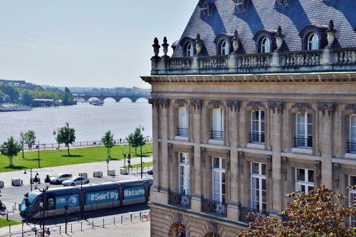 a train is parked in front of a building at Le Joyau by Cocoonr in Bordeaux