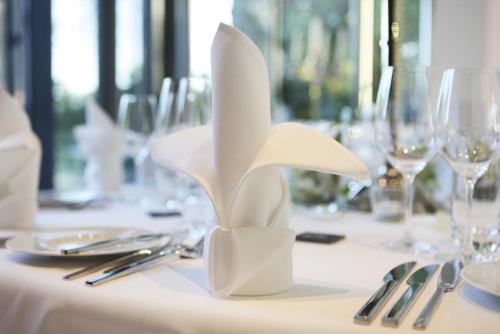 a table with a white centerpiece on a table with glasses at Best Western Plus Plaza Hotel Darmstadt in Darmstadt