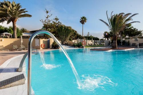 a pool with a water fountain in a resort at Hotel LIVVO Risco del Gato Suites in Costa Calma