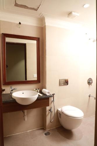 a bathroom with a sink and a toilet and a mirror at Hotel Golden Tower Near Heritage Street in Amritsar
