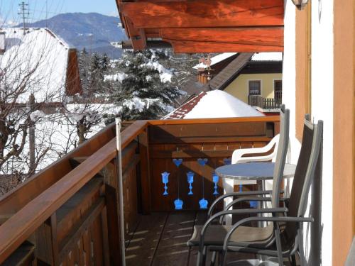 a porch with a table and chairs on a balcony at Ferienhaus Warmuth in Sankt Stefan an der Gail
