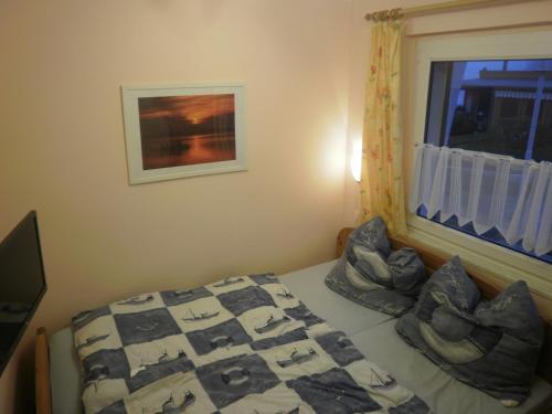 ein Schlafzimmer mit einem Bett mit Kissen und einem Fenster in der Unterkunft Canow in Canow