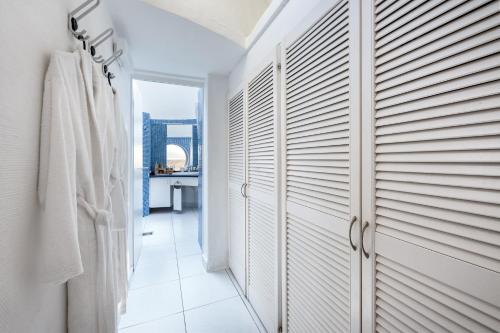 a bathroom with white walls and white towels at Hotel LIVVO Risco del Gato Suites in Costa Calma