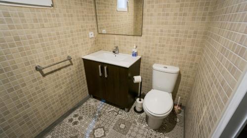 bagno con servizi igienici, lavandino e specchio di RentalSevilla Apartamento en Barrio Santa Cruz con Parking a Siviglia