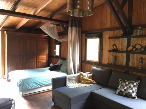 uma sala de estar com um sofá e uma cama em Les SenS de l'Escalette em Pégairolles-de-lʼEscalette