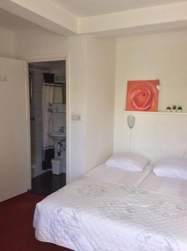 a bedroom with a bed and a painting on the wall at Hotel Pension Oranje in Valkenburg