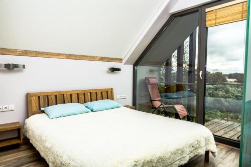 a bedroom with a bed and a balcony at Golden Beach in Šventoji