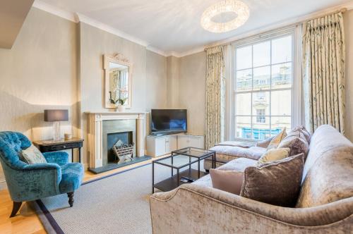 a living room with a couch and a fireplace at Luxury Apartments - 10 Royal Parade in Cheltenham